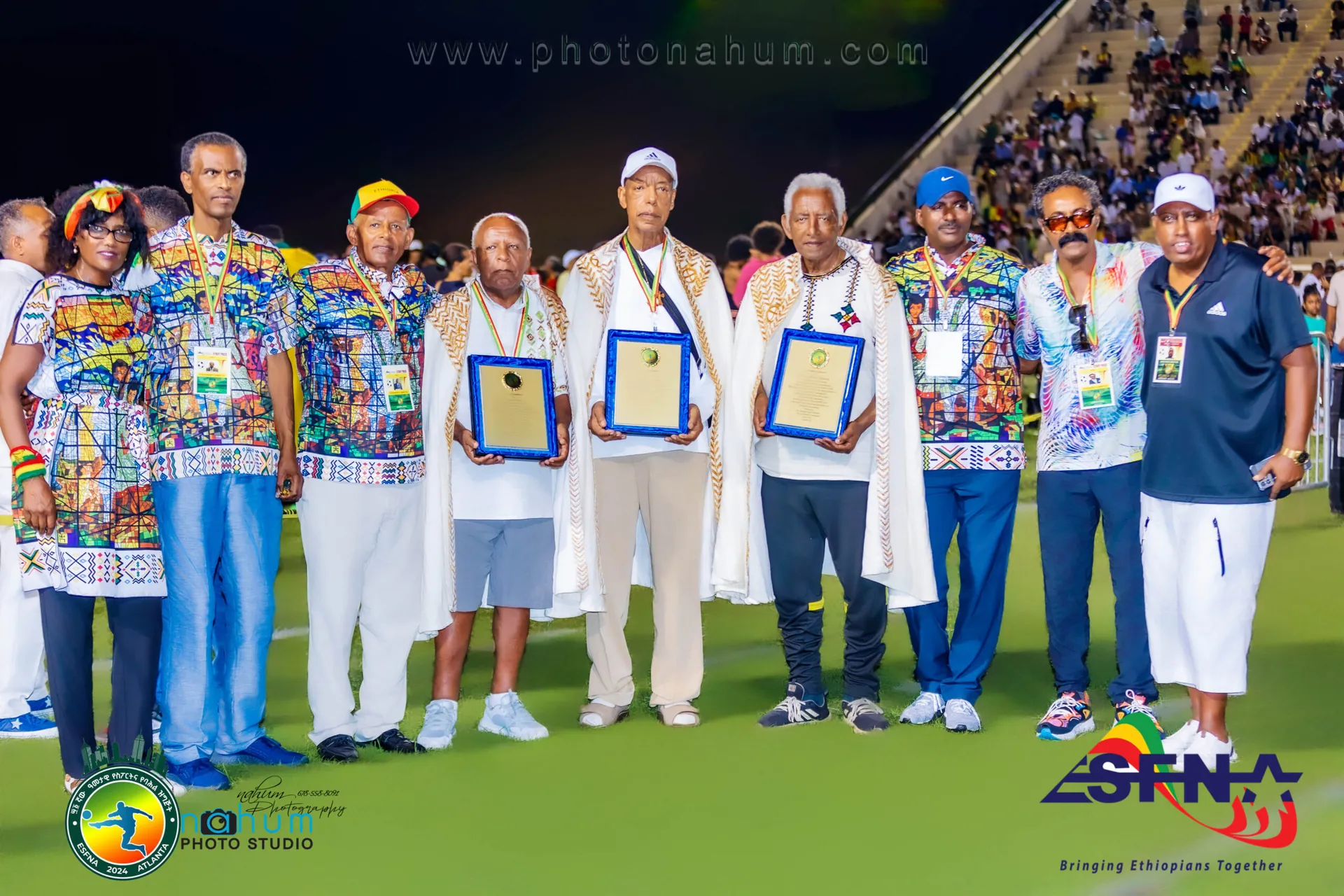 Honorees holding their plaques on the field