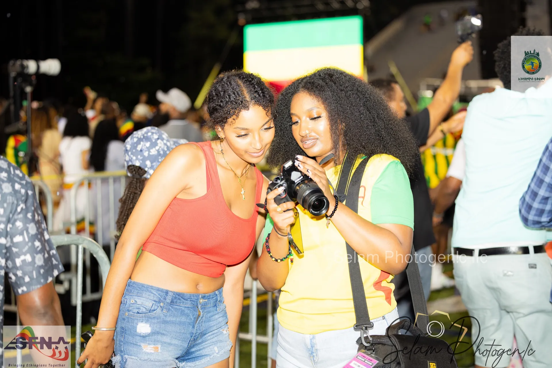 Two fans looking at photos on a camera